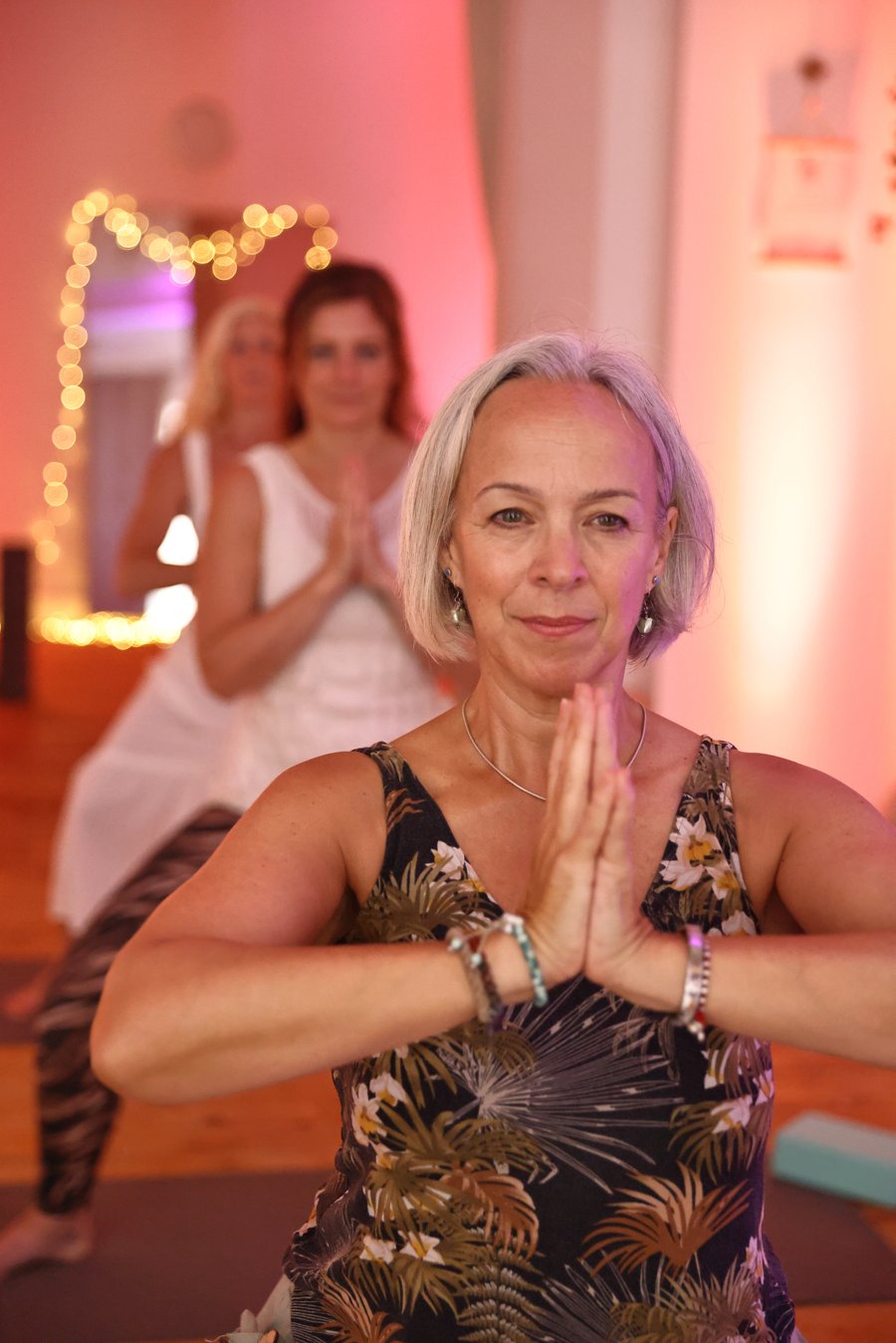 Karen in a yoga pose, hands together at heart centre