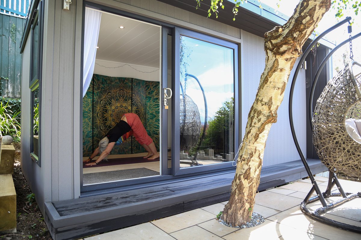 A yoga pose practised in the doorway of Karen's garden studio, with the gold and green mandala screen visible inside