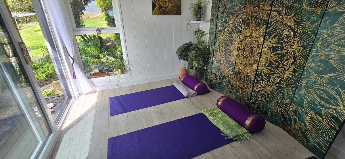 Two yoga mats and bolsters laid out ready for a session in the studio